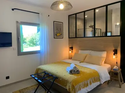 a bedroom with a large bed and a window at La Parenthese Saint Donat in Aix-en-Provence