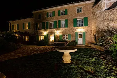 a building with green shutters and a bench in front of it at Pavillon Lou in Crillon-le-Brave