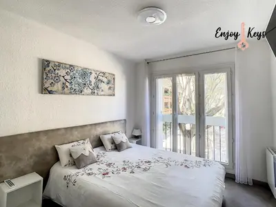 a bedroom with a bed and a large window at Au pied du Château de l'Empéri in Salon-de-Provence