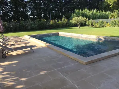 a swimming pool with two lounge chairs next to it at MAS DE CHARME EN PROVENCE in Le Thor
