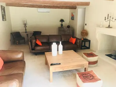 a living room with a leather couch and a coffee table at MAS DE CHARME EN PROVENCE in Le Thor