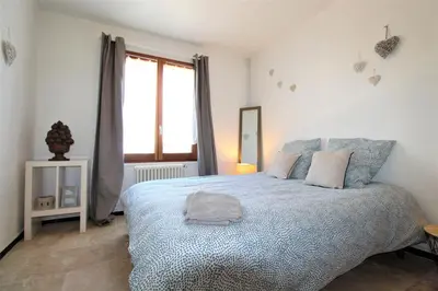a bedroom with a large bed and a window at Les Bastidons de L'Isle - Le Saint-Julien - 3 étoiles in LʼIsle-sur-la-Sorgue