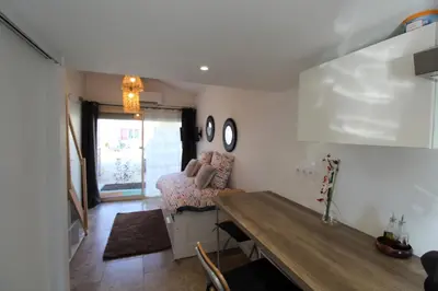 a living room with a table and a bed at Les Bastidons de L'Isle - st ju- 3 étoiles in LʼIsle-sur-la-Sorgue