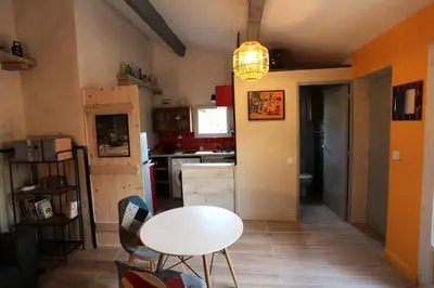 a kitchen with a table and a white table and chairs at LUBERON DES ARTISTES 2 in Apt