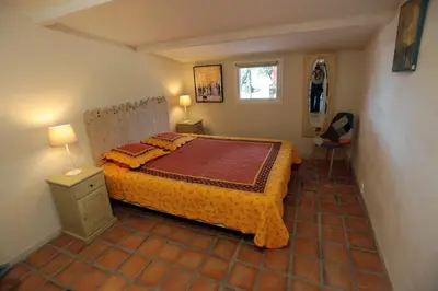 a bedroom with a bed and a table and a chair at LUBERON DES ARTISTES 2 in Apt