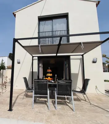 a patio with a table and chairs in front of a building at Les Bastidons de l'Isle - Le Seguret - 3 étoiles in LʼIsle-sur-la-Sorgue