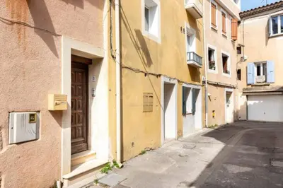 an empty alley with a building and a door at Le marronnier 3: Superbe appart au coeur de la petite venise in LʼIsle-sur-la-Sorgue