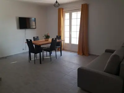 a living room with a table and chairs and a couch at Domaines des confines in Monteux