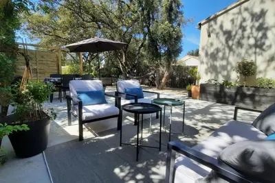 a patio with chairs and a table and an umbrella at Gîte des Bartavelles in Saint-Didier