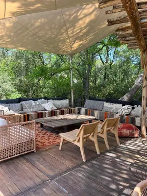 a patio with a table and chairs on a deck at La Bastide des Grands Chênes in Lambesc