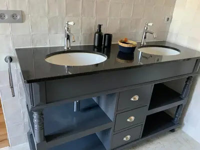 a bathroom with two sinks in a black counter at La Bastide des Grands Chênes in Lambesc