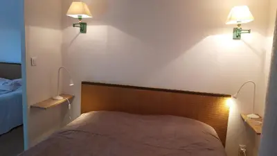 a bedroom with a bed with two lights on the wall at Mini gite foulon in Crillon-le-Brave