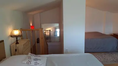 a bedroom with a bed and a mirror and a lamp at Mini gite foulon in Crillon-le-Brave