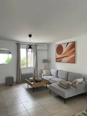 a living room with a couch and a table at Villa Lisa - piscine chauffée in LʼIsle-sur-la-Sorgue