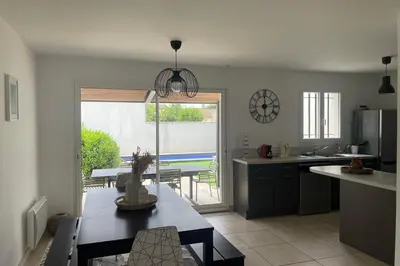 a kitchen with a table and a dining room with a patio at Villa Lisa - piscine chauffée in LʼIsle-sur-la-Sorgue