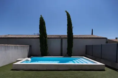 a swimming pool in a yard with two trees at Villa Anna - piscine privée proche du centre historique in LʼIsle-sur-la-Sorgue