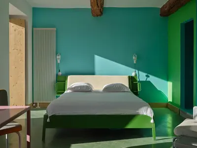 a bedroom with a bed with a blue and green wall at Domaine La Ferme HI bride in Villelaure