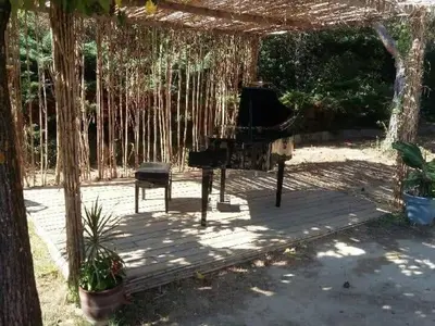 a grand piano under a pergola with a bench at Chambres tomate, dans maison avec petit escalier à 6km du festival de piano de la roque d'anthéron in Rognes