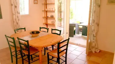 a dining room with a wooden table and chairs at Villa Chênaie in Bédoin