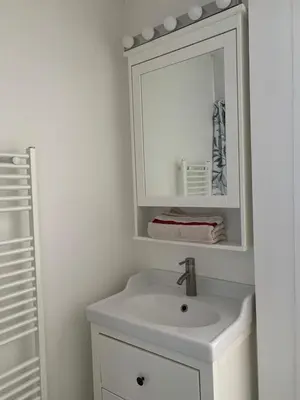 a white bathroom with a sink and a mirror at Beau T2 clim terrasse idéalement situé in Aix-en-Provence