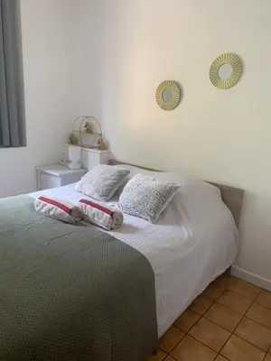 a bedroom with a bed with two mirrors on the wall at Beau T2 clim terrasse idéalement situé in Aix-en-Provence