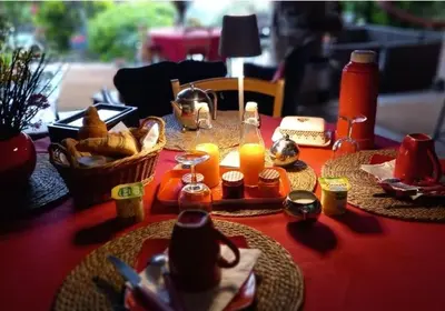 a table with some food and candles on it at Le jardin de Sabine in Éguilles