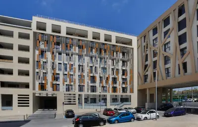 a large building with cars parked in a parking lot at Résidence Nemea Aix Campus 2 in Aix-en-Provence