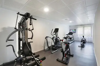 a gym with treadmills and exercise bikes in a room at Résidence Nemea Aix Campus 2 in Aix-en-Provence