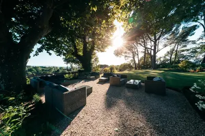 a group of couches sitting under a tree at Domaine Perréal Les Gîtes in Gargas