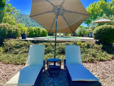 two chairs and a table with an umbrella at Domaine Perréal Les Gîtes in Gargas