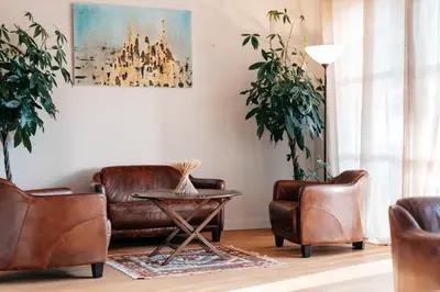 a living room with leather chairs and a table at Domaine Perréal Chambres d'hôtes in Gargas