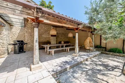 an outdoor patio with a picnic table and a grill at Le Mas Victoria in Gordes