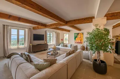 a living room with a large couch and a tv at Le Mas Victoria in Gordes