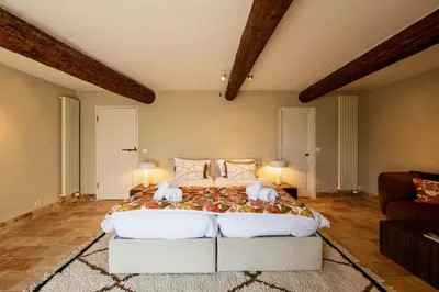 a bedroom with a large bed and a couch at Le Mas Victoria in Gordes