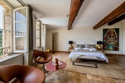 a bedroom with a bed and a painting on the wall at Le Mas Victoria in Gordes