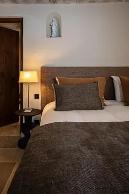 a bedroom with a large bed and a lamp at Le Mas Luca in Gordes