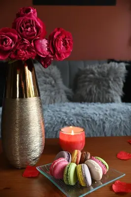 a table with a vase with roses and a candle at Eden House, Cocon sensuel et romantique avec jacuzzi in Carpentras