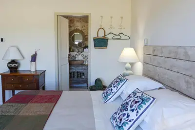 a bedroom with a large bed with blue and white pillows at La Bastide Neuve in Joucas