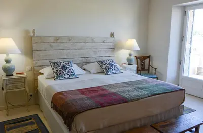a bedroom with a large bed with a wooden headboard at La Bastide Neuve in Joucas