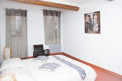 a bedroom with a bed and a picture on the wall at Appartement de Charme in Aix-en-Provence