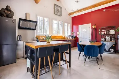 a kitchen with red walls and a table and chairs at Maison de Charme en Provence avec jardin et piscine in Carpentras