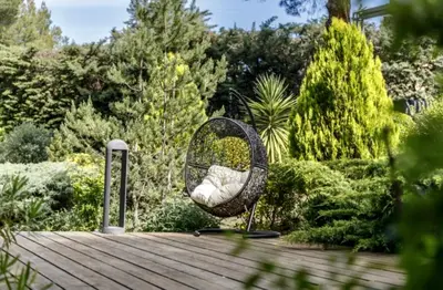 a wicker chair sitting on top of a wooden deck at Provence mon amour in La Tour-dʼAigues