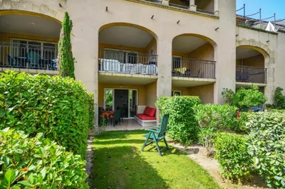 a house with a green chair in the yard at Village Pont Royal en Provence - maeva Home - Studio 5 Personnes Selection MAE-4892 in Mallemort