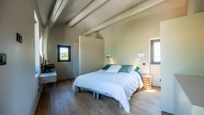 a bedroom with a white bed and a wooden floor at La Terrasse d'Eygalières in Eygalières