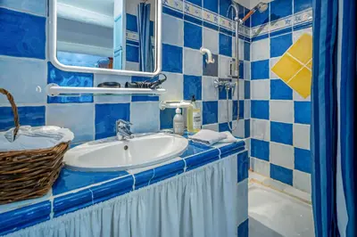 a blue and white bathroom with a sink and a mirror at Clos des Hérissons - Chambres d'Hôte - Piscine & jardin in Lauris