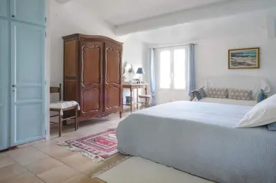 a bedroom with a bed and a cabinet and a window at Clos des Hérissons - Chambres d'Hôte - Piscine & jardin in Lauris