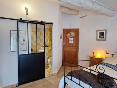a room with a glass door leading to a bedroom at Clos des Hérissons - Chambres d'Hôte - Piscine & jardin in Lauris