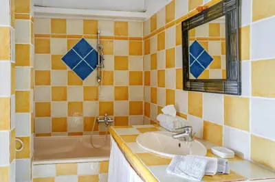 a bathroom with a sink and a tub and a mirror at Clos des Hérissons - Chambres d'Hôte - Piscine & jardin in Lauris