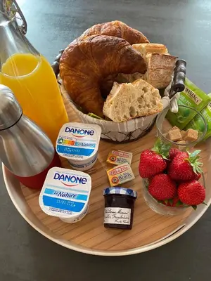 a plate of breakfast food with bread and strawberries at Les Célestins - Studios indépendants in Carpentras
