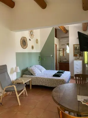 a bedroom with a bed and a table in a room at Les Célestins - Studios indépendants in Carpentras